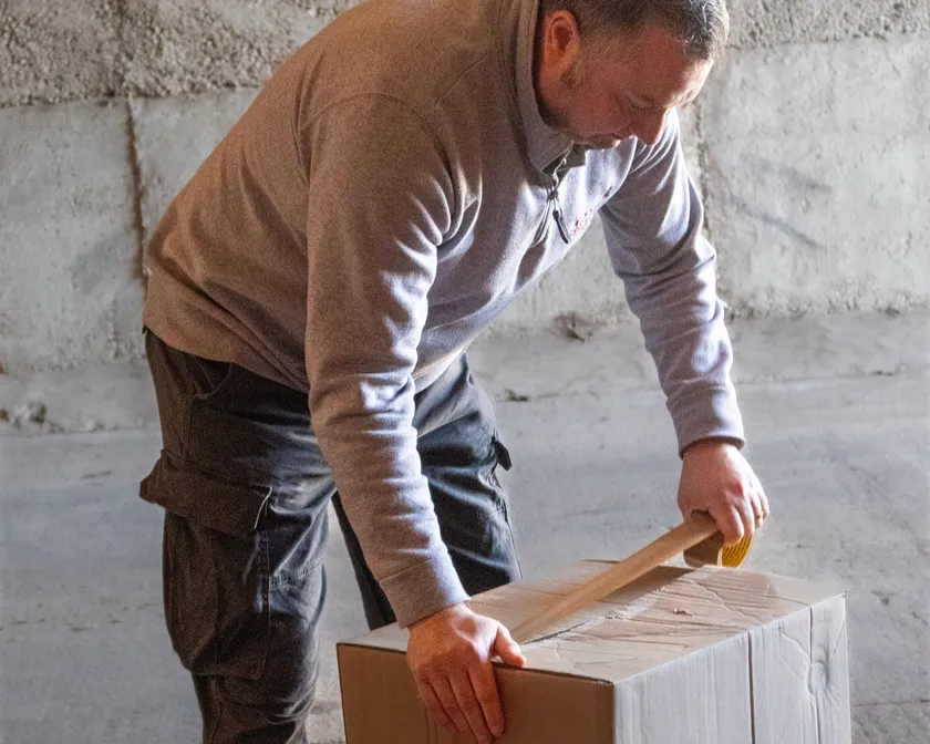 An Acorn team member taping a heavy-duty carton at the depot