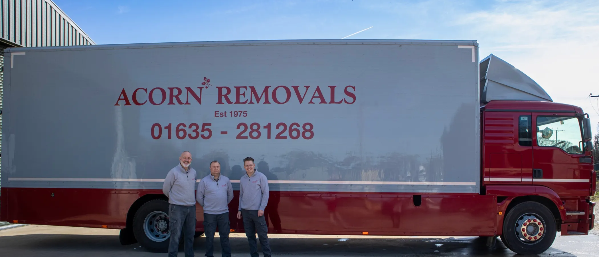 The Acorn team standing alongside a branded lorry at the Newbury depot